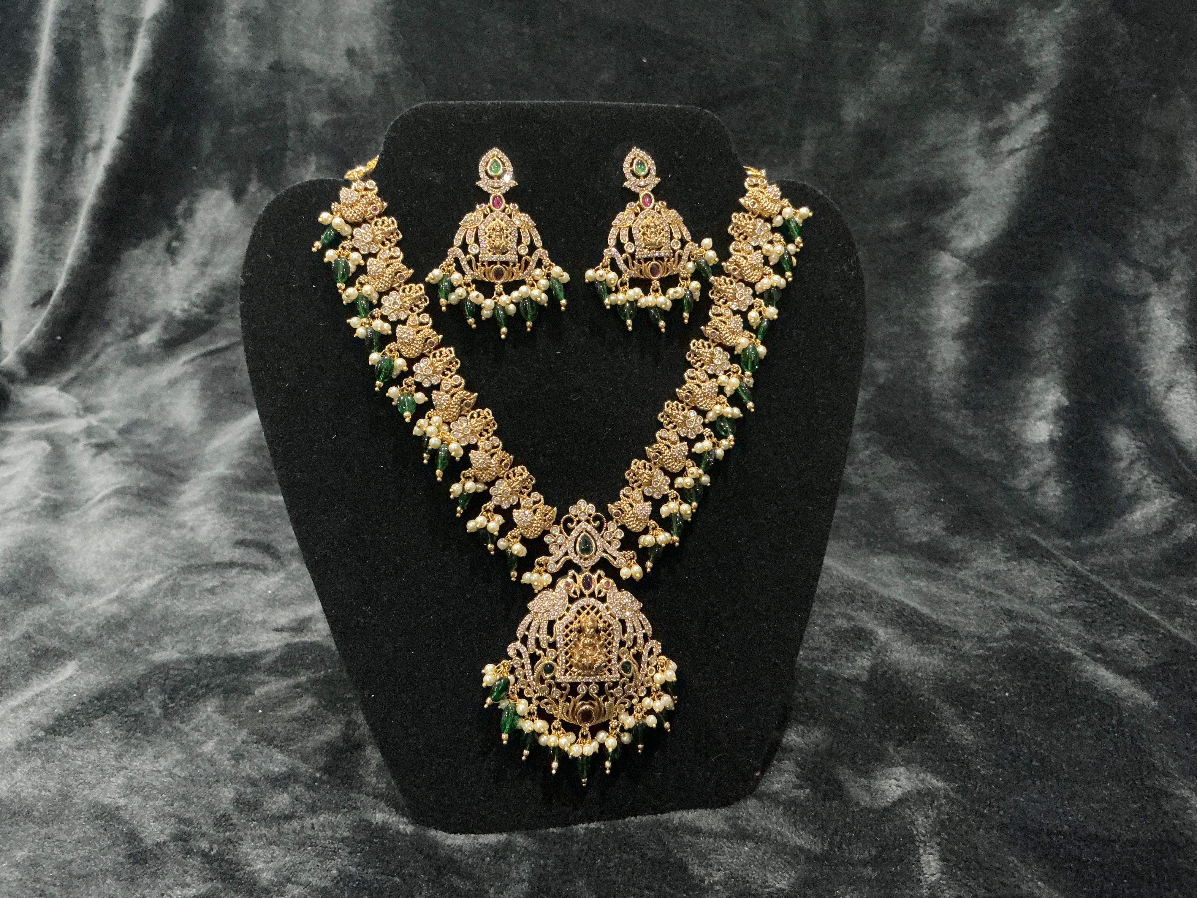 Traditional temple bridal necklace set with green beads, pearl detailing, and matching earrings