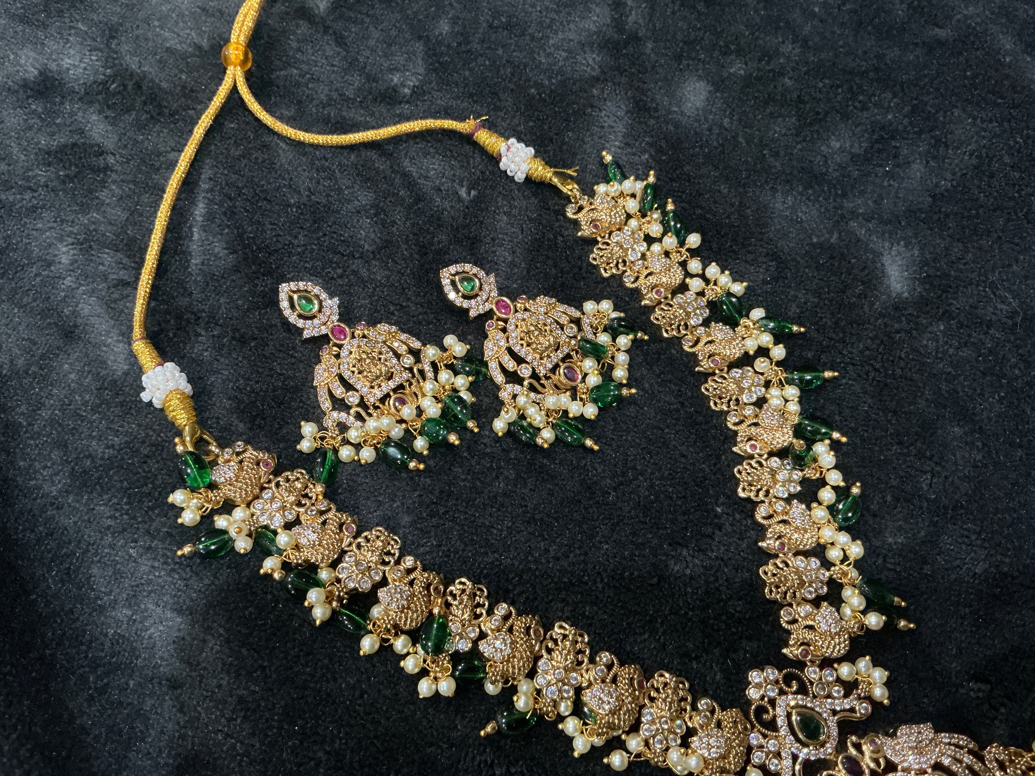 Traditional temple bridal necklace set with green beads, pearl detailing, and matching earrings
