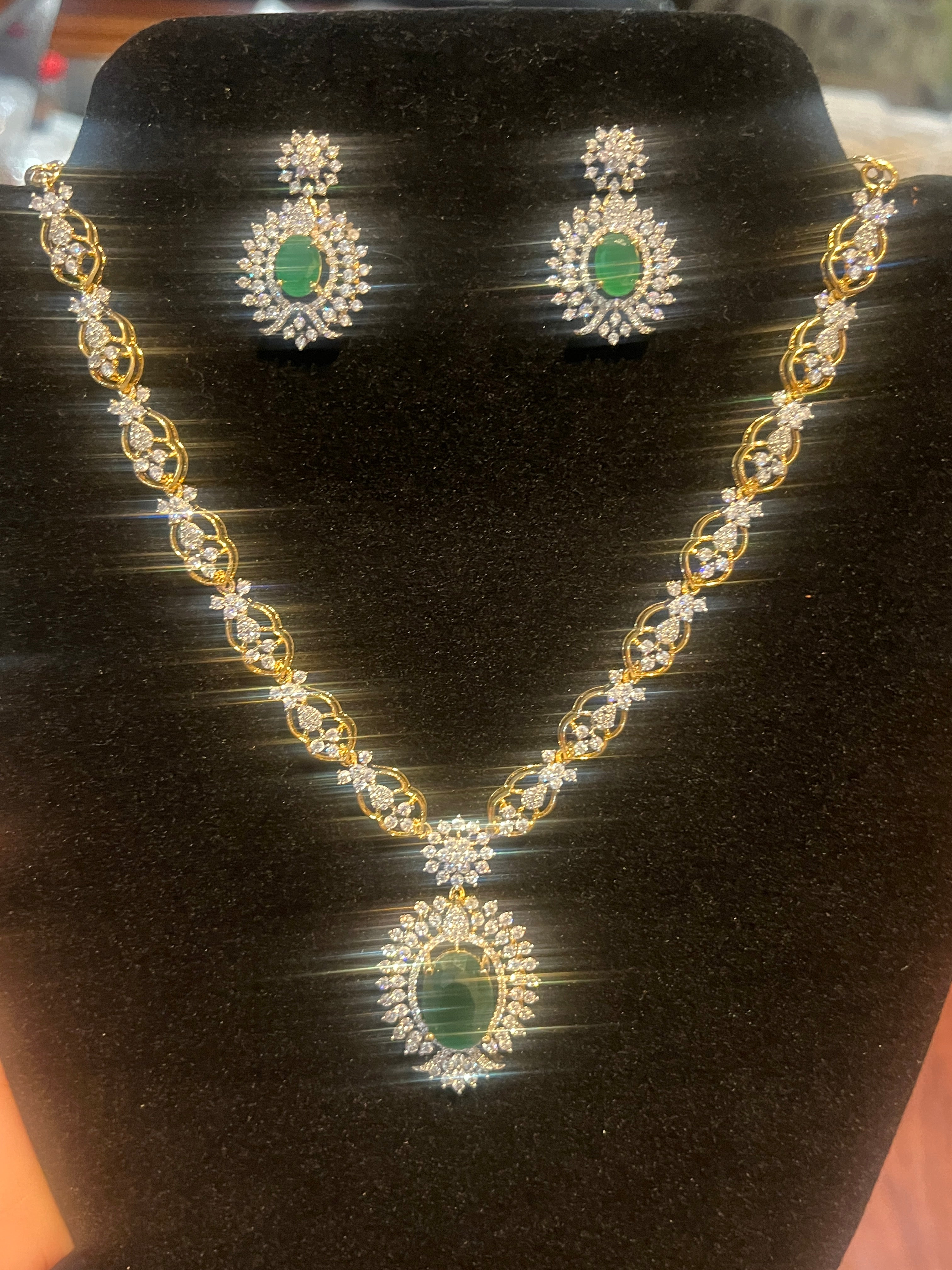 Elegant partywear necklace set with emerald stones and diamond-look CZ accents
