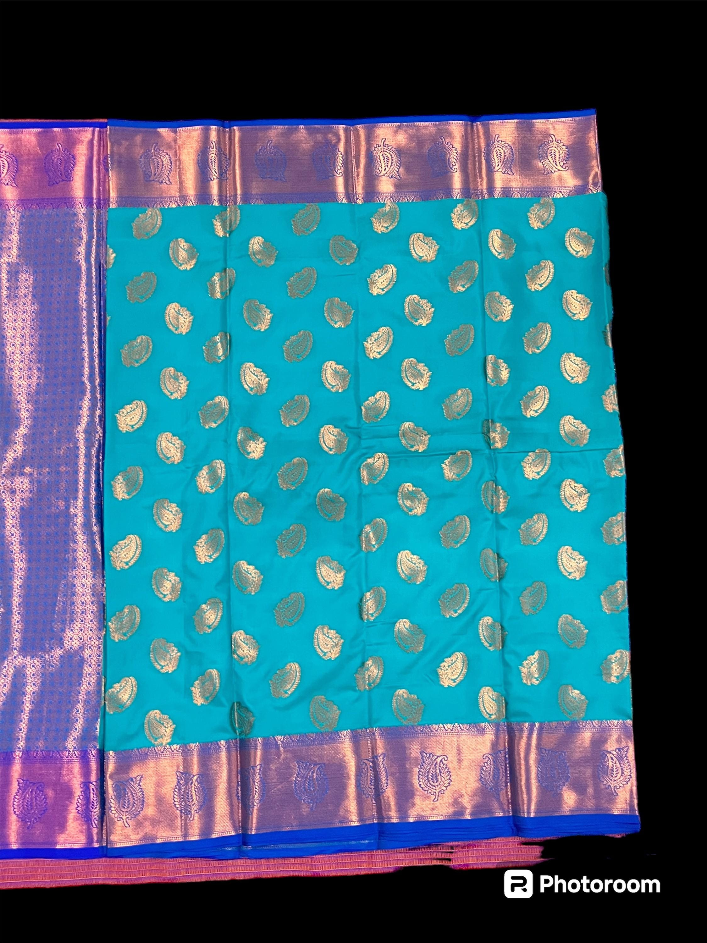 Turquoise handwoven Kanchi silk saree with gold zari paisley motifs and purple bordered edge.