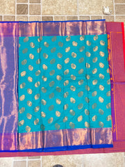 Turquoise handwoven Kanchi silk saree with gold zari paisley motifs and purple borders.