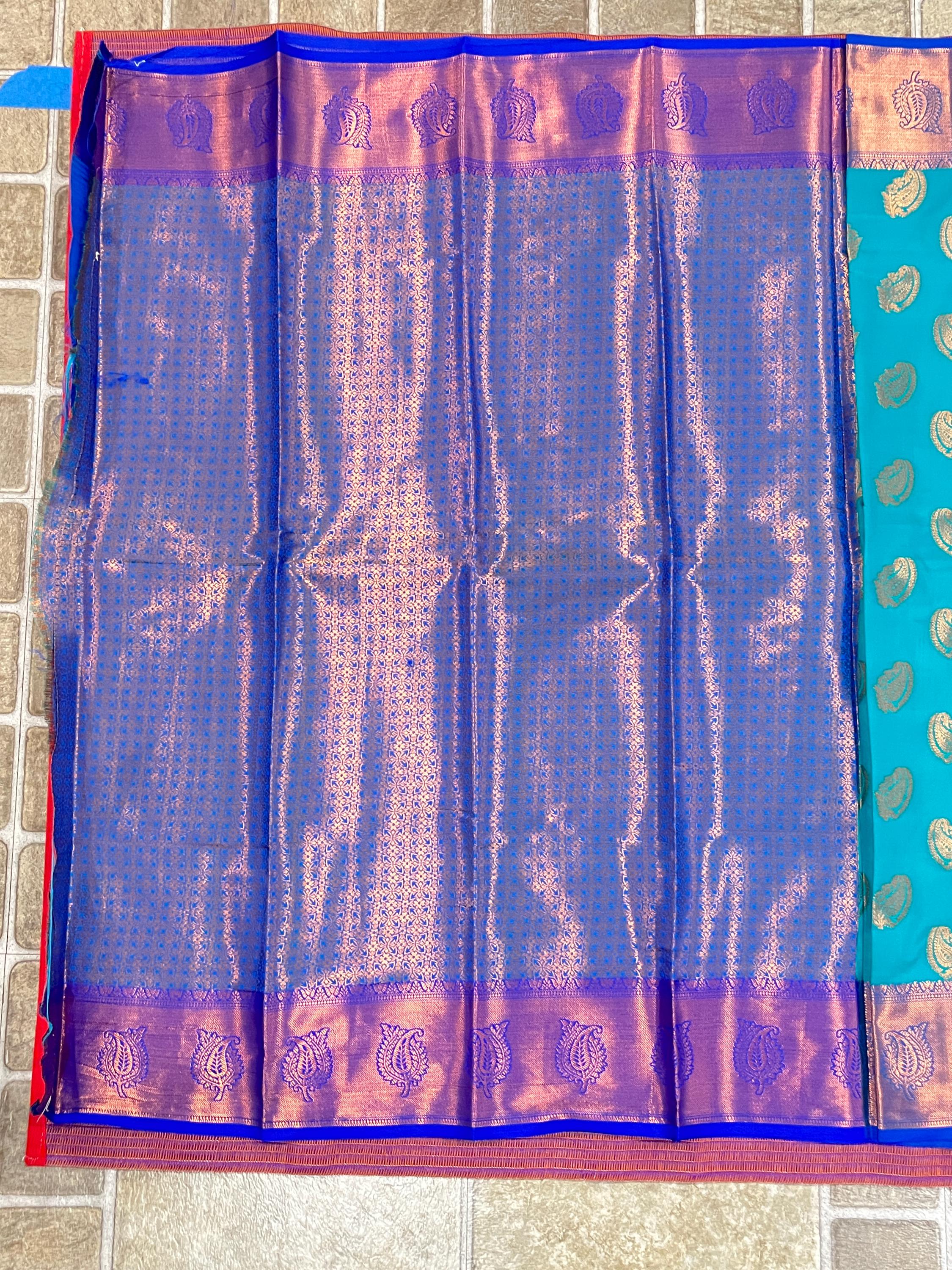 Handwoven Kanchi silk saree with zari work for Indian weddings in royal blue with pink border.