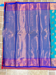 Handwoven Kanchi silk saree with zari work for Indian weddings in royal blue with pink border.