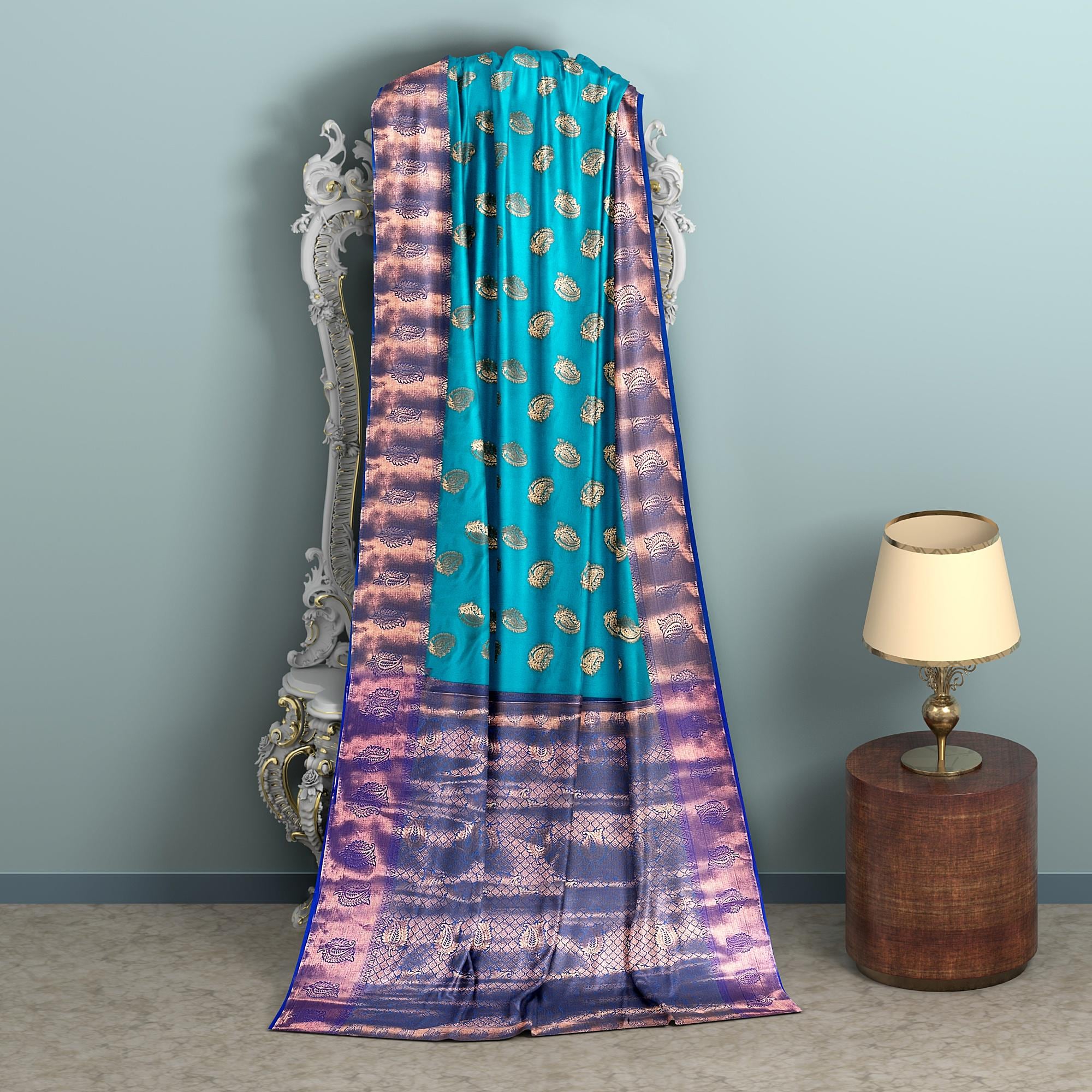 Handwoven Kanchi silk saree with zari work for weddings, turquoise with purple border, draped over an ornate mirror.